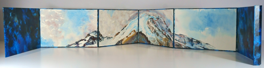 Photo of Suze Woolf accordion-fold artist book with watercolor painting of Mt. Rainier